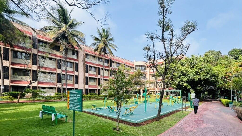 Jindal Naturecure Institute का हरा-भरा कैंपस, ओपन जिम और प्राकृतिक चिकित्सा केंद्र का दृश्य।